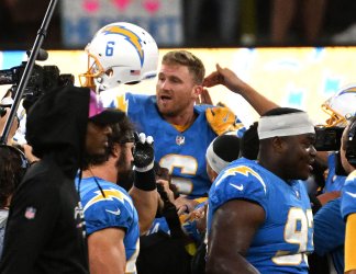 Chargers kicker Dustin Hopkins is lifted in the air after beating the Broncos with game winning field goal