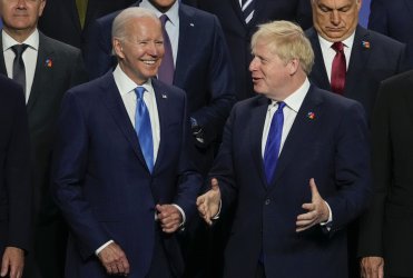 President Biden listens to British Prime Minister Boris Johnson during a NATO summit in Madrid