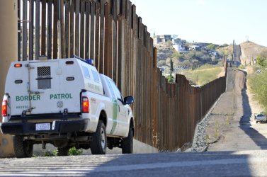 Border Patrol truck sits by United States-Mexico border fence in Nogalas, Arizona.