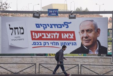 An Israeli Walks  Past An Election Campaign Poster In Jerusalem