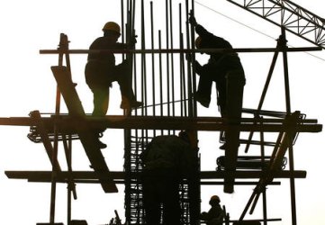 CONSTRUCTION WORKERS ASSEMBLE REBAR COLUMNS