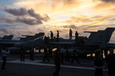 Sailors stand on F/A-18F Super Hornet to watch 4th of July fireworks
