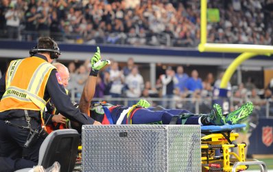 Seahawks wide receiver Ricardo Lockette signals to fans as he is taken off the field on a stretcher
