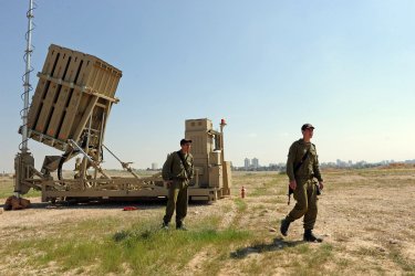 Israeli soldiers stand near the new Israeli anti-rocket system, the Iron Dome, in southern Israel