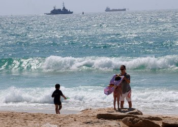 An Israeli family enjoys the beach near the Ashdod military port