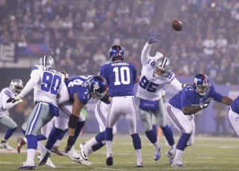 Cowboys David Irving leaps near Giants Eli Manning