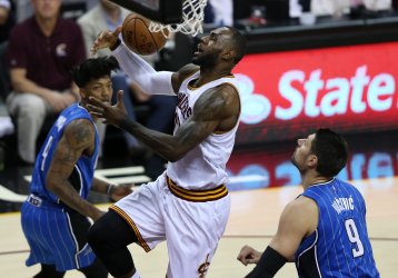 Cleveland Cavaliers LeBron James loses the handle on the ball while defended by Orlando Magics Nikola Vucevic