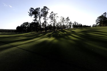 The sun sets behind the first hole fairway at the Masters