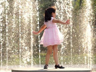 Chinese girl plays next to water fountain in Beijing