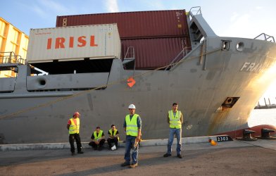 Israeli port workers stand beside the Francop ship carrying Iranian supplied arms