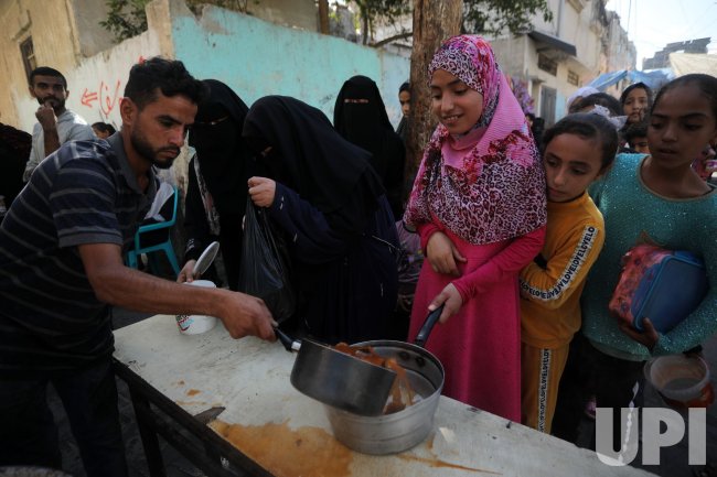 Palestinian Children Receive Portion of Food at a Make-Shift Charity Kitchen