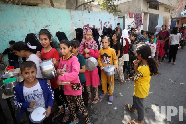 Palestinian Children Receive Portion of Food at a Make-Shift Charity Kitchen