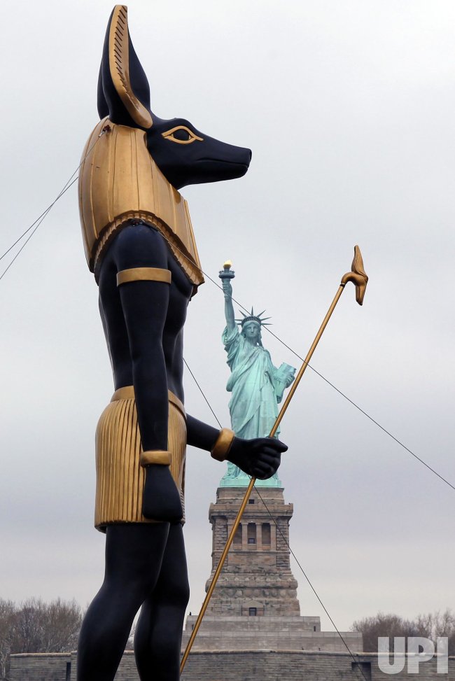 7 Ton Replica Statue of the Egyptian God Anubis passes by the Statue of Liberty in New York