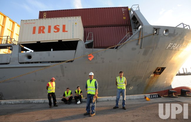Israeli port workers stand beside the Francop ship carrying Iranian supplied arms