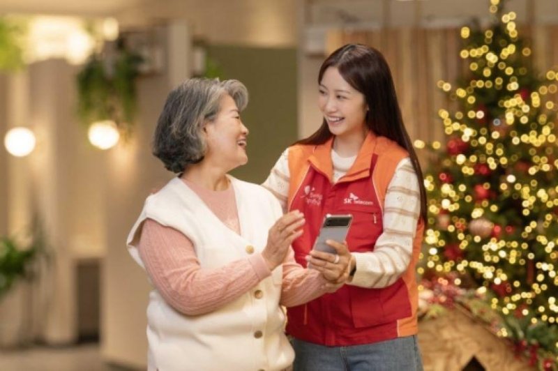 An SK Telecom employee shows a senior citizen how to use the AI call services in South Korea. Photo courtesy of SK Telecom
