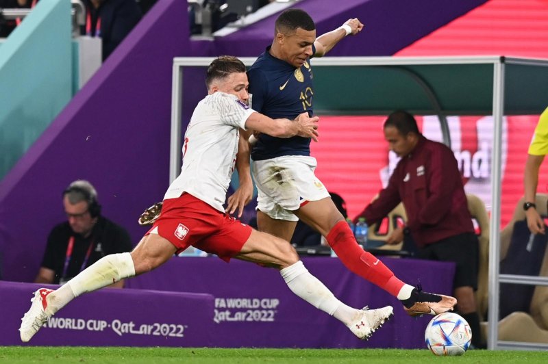 France's Kylian Mbappe jostles with Poland's Matty Cash during France's 3-1 win in the World Cup Round of 16 on Sunday. Photo by Georgi Licovski/EPA-EFE.