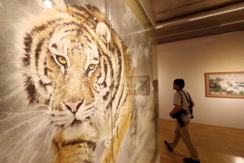 A visitor walks past a North Korean painting, "A Tiger Running in The Snow," during the 2018 Gwangju Biennale at the Asia Culture Center in Gwangju, South Korea, on Thursday. Photo by Yonhap