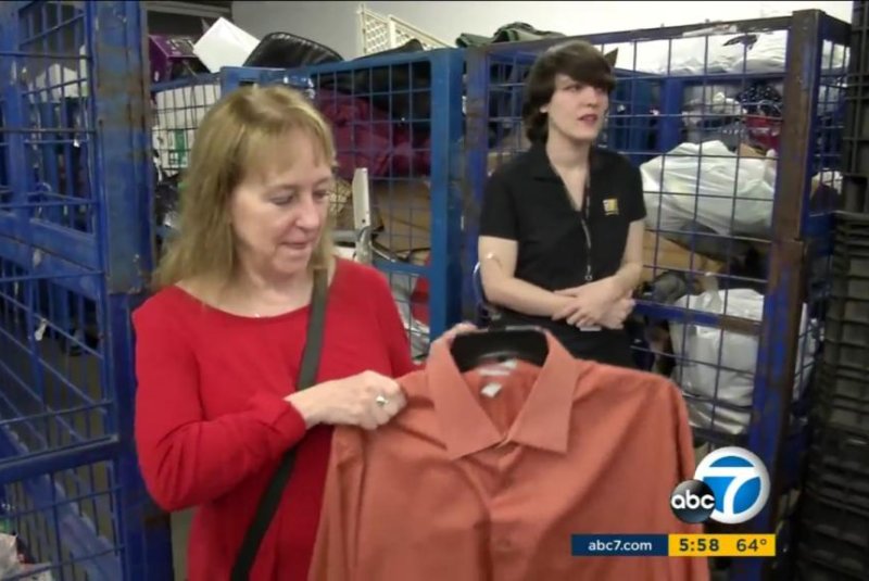 Linda Hoffman holds the shirt she donated to Goodwill without realizing her husband had hidden an envelope containing $8,000 cash in the pocket. Screenshot: KABC-TV