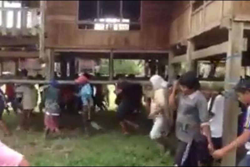 Residents of a Thai village lift and carry an entire house. Screenshot: YouLike/Facebook