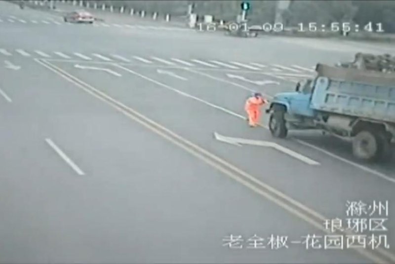A gravel truck nearly strikes a street cleaner in China. Newsflare video screenshot