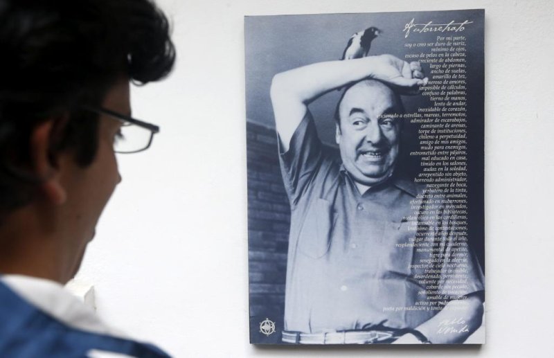 A visitor looks at a photo of Chilean poet Pablo Neruda in Santiago, Chile, in 2013. Last week, an international team of forensic experts concluded Neruda, who died on September 23, 1973, did not die of prostate cancer. File Photo by Felipe Trueba/EPA-EFE