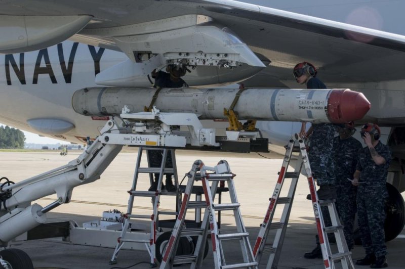 Aviation Ordnanceman 3rd Class Michael Martin, left, and Aviation Ordnanceman Airman Cecilia Duran, load an AGM-84K SLAM-ER missile on a P-8A Poseidon in preparation for a conventional weapons technical proficiency inspection. Photo by Mass Communication Specialist 3rd Class Jason Kofonow/U.S. Navy