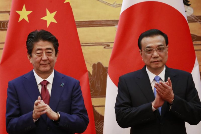 Japanese Prime Minister Shinzo Abe (L) and Chinese Premier Li Keqiang (R) clap during a signing ceremony at the Great Hall of the People in Beijing, China, on Friday. Photo by How Hwee Young/EPA-EFE