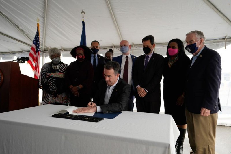 Virginia Gov. Ralph Northam (seated) signs legislation repealing the death penalty in the state surrounded by members of the General Assembly on Wednesday. Photo courtesy of Gov. Ralph Northam's office