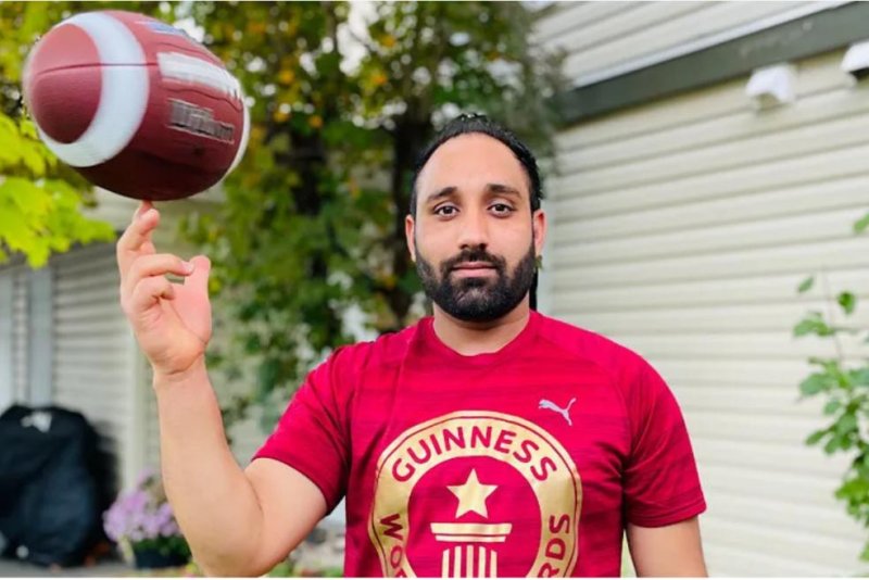 Sandeep Singh Kaila of Abbotsford, British Columbia, set a Guinness World Record by spinning a football on his finger for 21.66 seconds. Photo courtesy of Guinness World Records