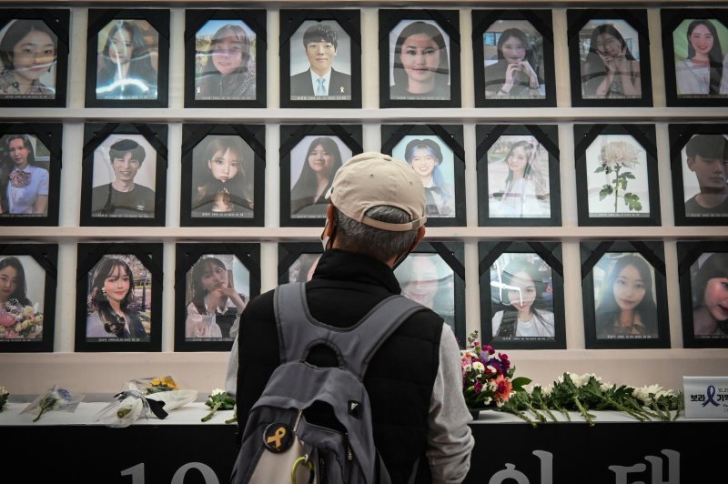 A visitor looks at the portraits of victims of the Itaewon Halloween tragedy at a memorial maintained by families and supporters in downtown Seoul on Thursday. Photo by Thomas Maresca/UPI