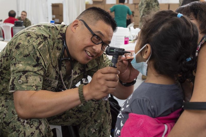 Lt. Cmdr. John Arce, a Navy Doctor, assigned to hospital ship USNS Comfort, checks a patient's mouth at a temporary medical treatment center in Manta, Ecuador. Photo by Mass Communication Spec. 3rd Class Brendan Fitzgerald/U.S. Navy