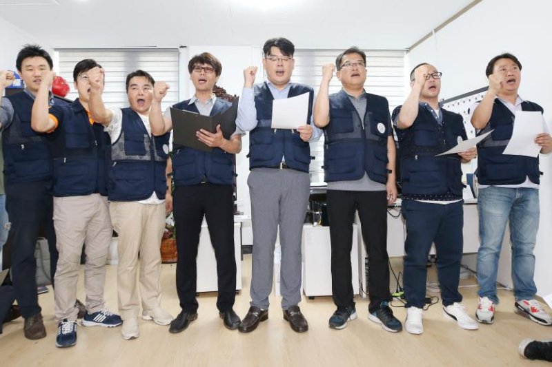 Representatives of an association of convenience store operators chant slogans at a press conference in Seoul on Monday, decrying a hike in the minimum wage. Photo by Yonhap