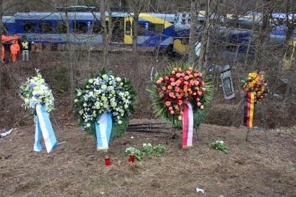 As train cars are removed, a makeshift memorial notes the spot two trains crashed head-on Tuesday near Munich, Germany, killing ten people and injuring hundreds. Photo by Bavarian State Government.