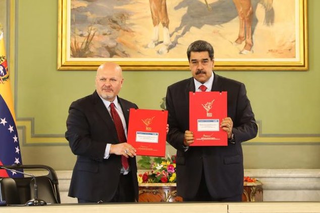 ICC prosecutor Karim Khan (L) and Venezuelan President Nicolas Maduro hold up a memorandum of understanding that states despite their differences the ICC will launch an investigation into allegations of crimes committed in Venezuela in 2017. Photo courtesy of the International Criminal Court/Twitter