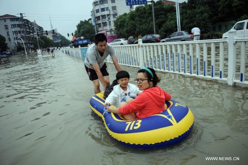 This photo from China's government-controlled news agency Xinhua shows local residents taking a lifeboat on a waterlogged road in downtown Yuyao City, east China's Zhejiang Province, Oct. 9, 2013. The continuous rainfall brought by Typhoon Fitow caused heavy waterlog in a large area of Yuyao. (Xinhua/Han Chuanhao)