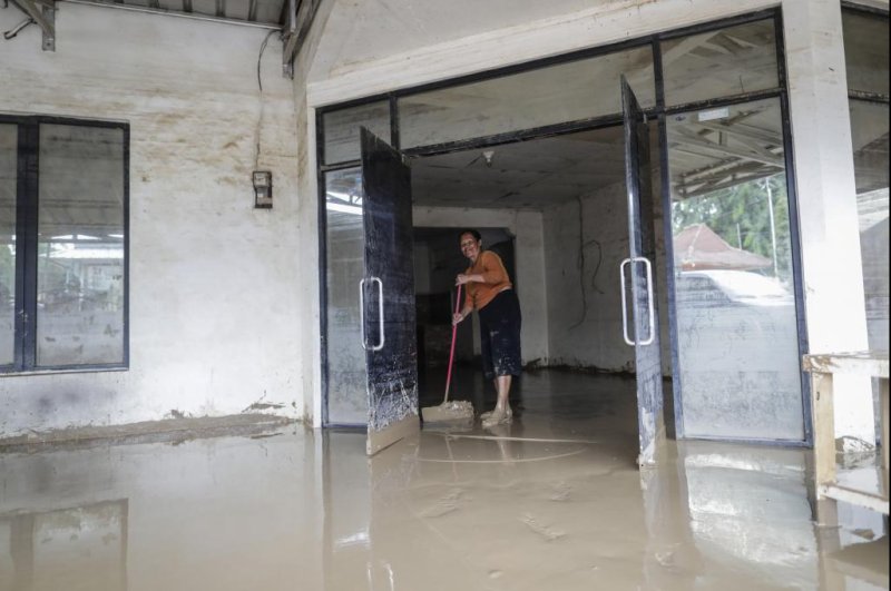 A woman cleans a house at a residential area affected by floods in Bekasi, West Java province, Indonesia on Friday. Photo by Mast Irham/EPA-EFE