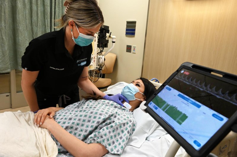 A nurse at El Camino Health demonstrates the FloPatch device. Once placed on the patient's neck, the Food and Drug Administration-approved device assesses blood flow in the carotid arteries and wirelessly transmits data to a secure mobile application to provide clinicians with real-time data. Photo courtesy of El Camino Health