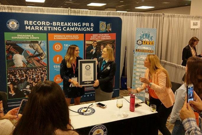 Rachel Musiker receives a Guinness World Records certificate for fastest time to type the alphabet on a touch screen mobile phone at a conference in Texas. Photo courtesy of Guinness World Records