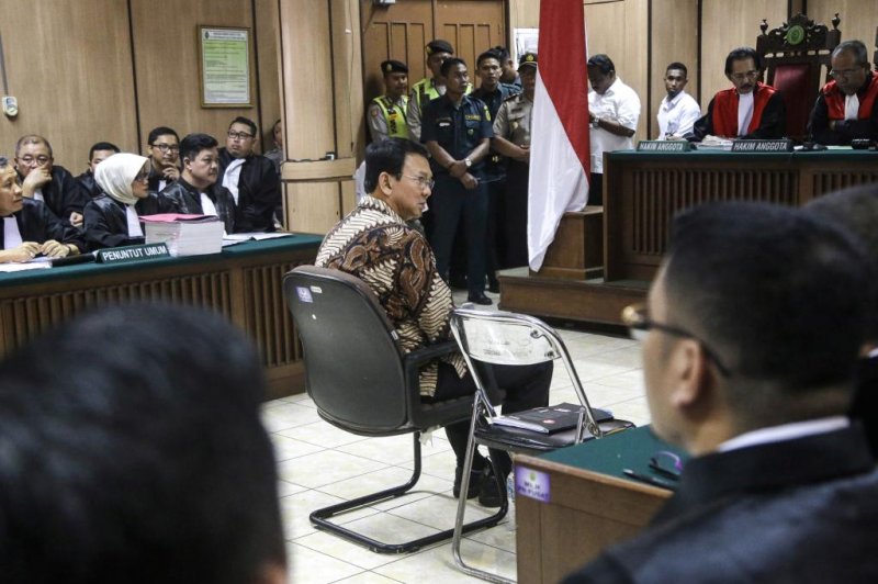 Jakarta Governor Basuki Tjahaja Purnama, known by the nickname Ahok, at center, sits in the defendant's chair in a courtroom shortly before his blasphemy trial hearing at North Jakarta District Court in Jakarta, Indonesia, on December 13, 2016. Ahok is on trial for blasphemy due to comments he made in reference to a Koranic verse while campaigning in September 2016. Photo by Tatan Syuflana/Pool/European Pressphoto Agency