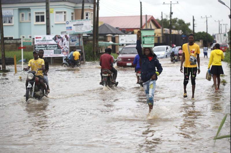 People wade through a flooded road after rain falls in Lagos, Nigeria, on September 12. The continued flooding has killed more than 600 people as of Sunday, officials said. Photo by Akintunde Akinleye/EPA-EFE