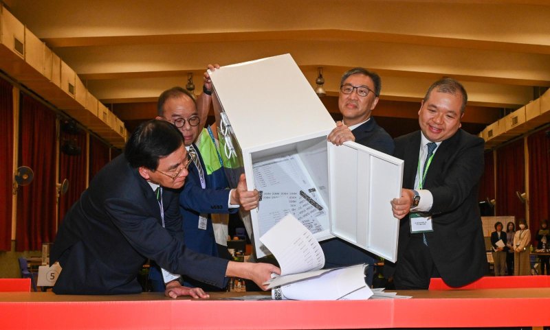 Chairman of the Electoral Affairs Commission Justice David Lok (second right), and Secretary for Constitutional and Mainland Affairs Erick Tsang Kwok-wai (second left) empty a ballot box at the District Committees constituency counting station of the 2023 District Council Ordinary Election at Ng Wah Catholic Secondary School on Sunday night. A record low 1.19 million registered voters cast ballots in the election. Photo courtesy Government of Hong Kong Special Administrative Region