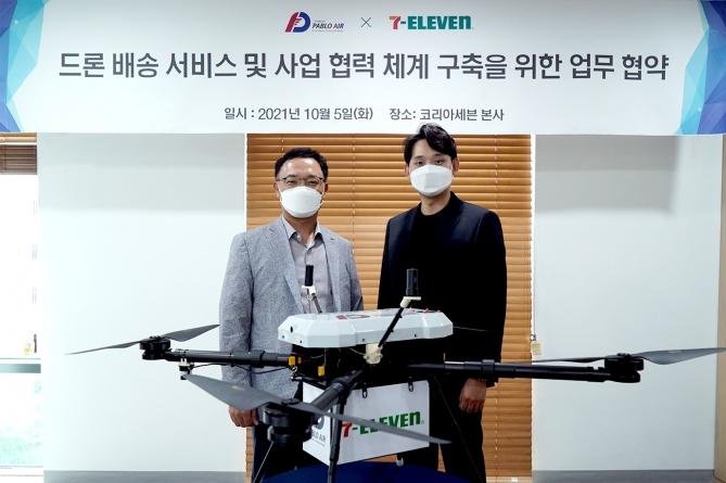 Korea Seven CEO Choi Kyung-ho (L) poses with Pablo Air CEO Kim Young-joon after signing a partnership for drone delivery services at Korea Seven’s head office in Seoul on Tuesday. Photo courtesy of Korea Seven