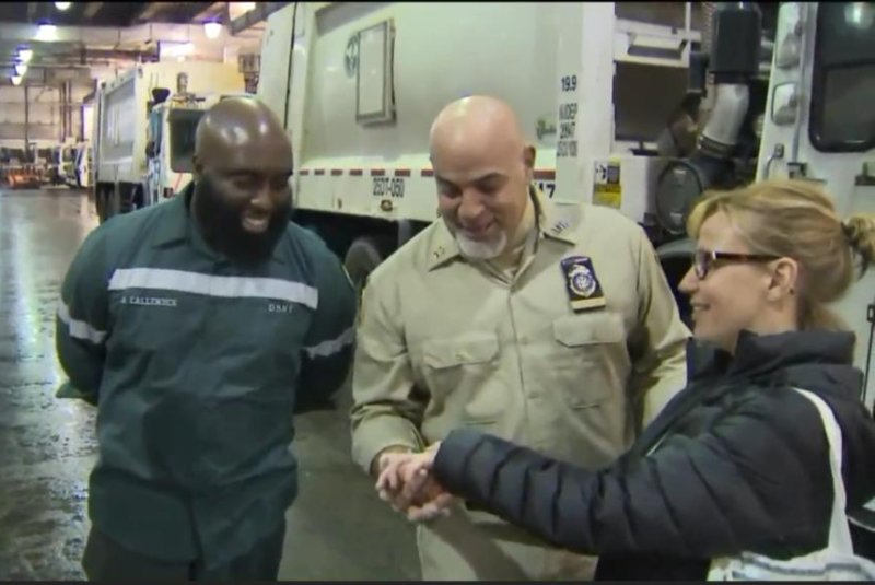 A New York woman shows her recovered rings to sanitation workers who helped her recover them at a New Jersey processing facility. Screenshot: WPIX-TV
