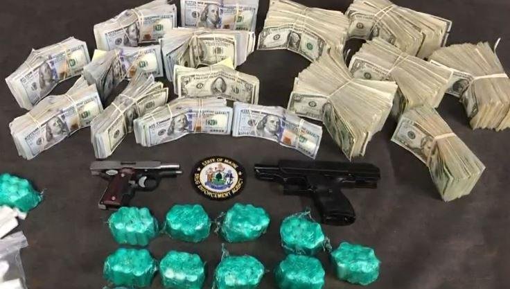 Police in Sanford, Maine, displayed cash and a heroin/fetanyl mixture seized in the arrest of two people who were charged with drug trafficking, the Maine Drug Administration Administration said Monday. Screenshot from WCSH-TV, Portland, Maine