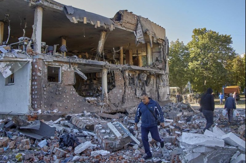 Residents are seen walking near a destroyed administrative building in Kharkiv, Ukraine, on Wednesday following a Russian rocket attack. Photo by Sergey Kozlov/EPA-EFE