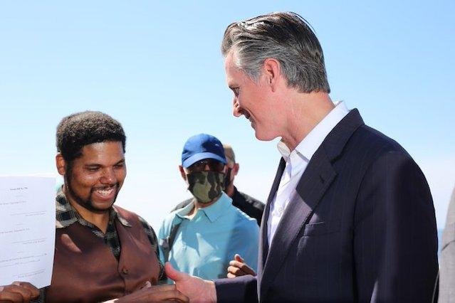 California Gov. Gavin Newsom (R) and Anthony Bruce (L) on Bruce's Beach after Newsom signed a bill in 2021 returning the $21 million Los Angeles County beach-front property to the Bruce family. Photo courtesy of Gavin Newsom/Twitter