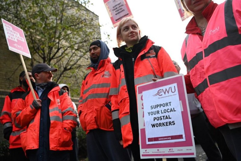 Royal Mail workers hold signs outside a Royal Mail depot in London on Thursday as the Communication Workers Union called for a strike across the country. Photo by Andy Rain/EPA-EFE