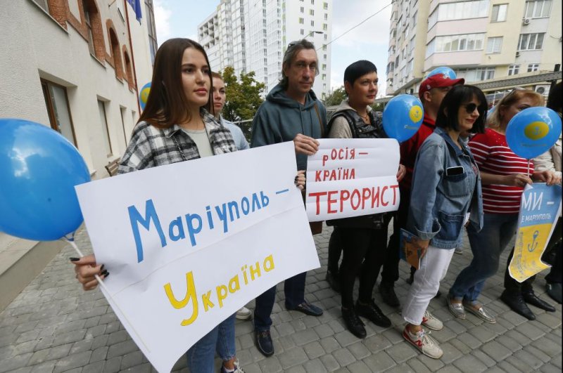 A group of internally displaced people from Mariupol hold Ukrainian flags and placards reading "Russia is the terrorist country: at a rally in Odesa Saturday, the second of five days of what they call a "sham referendum" in Russian-controlled regions of eastern and southern Ukraine. Photo by Stringer/EPA-EFE
