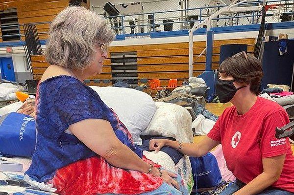A volunteer with the Red Cross speaks with a woman at a shelter in eastern Kentucky, where the death toll was expected to rise on Monday. Photo courtesy Kentucky Red Cross/<a href="https://www.facebook.com/redcross/posts/pfbid0MDoCBCd5js9895uM66G4JiHnE8qyT4biud2BHXkALXU1Ys4cs3cHmfNCAMWipZpBl">Facebook</a>