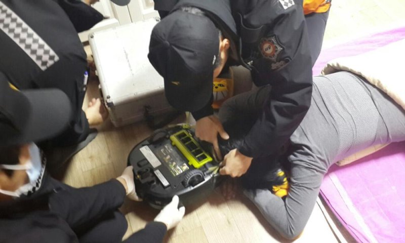 Firefighters try to rescue a woman at her house in Changwon, southeast South Korea, on Feb. 3, 2015, after her hair was sucked into a robot vacuum cleaner. She lost about 10 strands of hair but was not injured. Photo by Yonhap